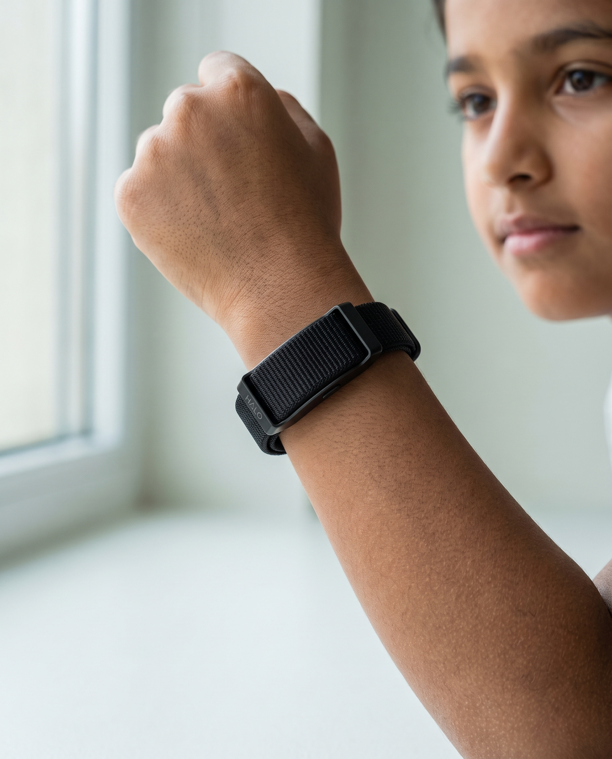 A child wearing the Halo Lytt band on their wrist